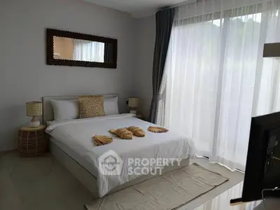 Spacious bedroom with large window and elegant decor in modern apartment.