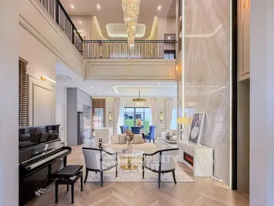 Luxurious double-height living room with elegant chandelier and grand piano