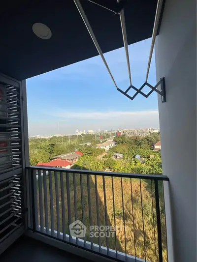 Stunning balcony view overlooking lush greenery and cityscape, perfect for relaxation and enjoying the outdoors.