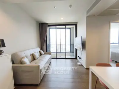 Modern living room with sleek design and balcony view in a high-rise apartment.