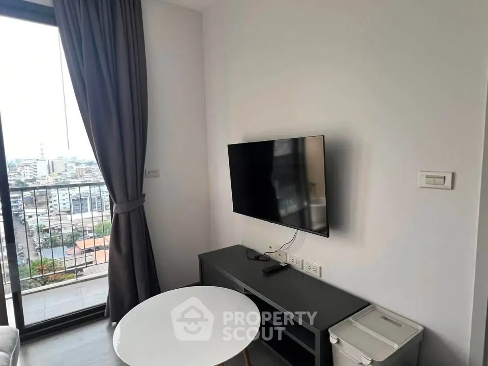 Modern living room with city view, wall-mounted TV, and sleek furniture.