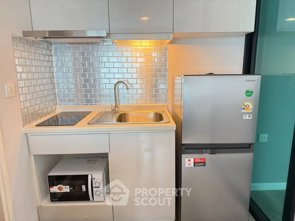 Modern compact kitchen with sleek appliances and stylish backsplash