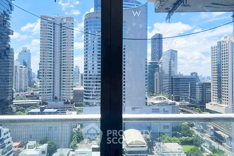 Stunning cityscape view from a high-rise balcony showcasing modern skyscrapers and vibrant urban life.
