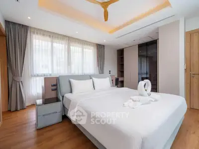 Luxurious bedroom with elegant decor and ample natural light, featuring a stylish wardrobe and cozy ambiance.