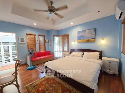 Spacious bedroom with elegant decor and natural light, featuring a cozy bed and stylish furnishings.