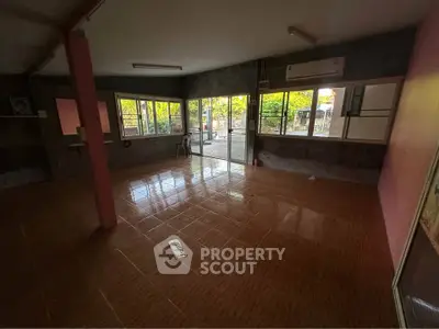 Spacious room with large windows and tiled flooring, perfect for versatile use.