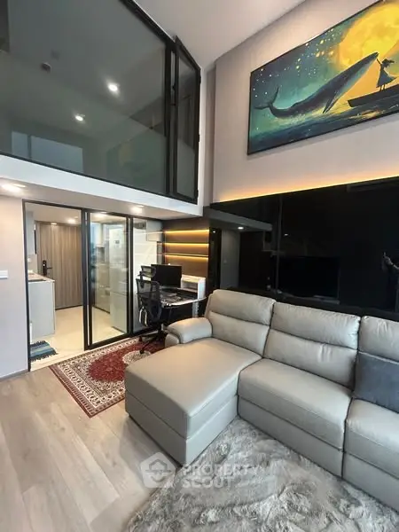 Modern living room with high ceiling and mezzanine, featuring a cozy sectional sofa and stylish decor.