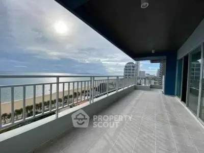 Spacious balcony with stunning ocean view in modern high-rise building.