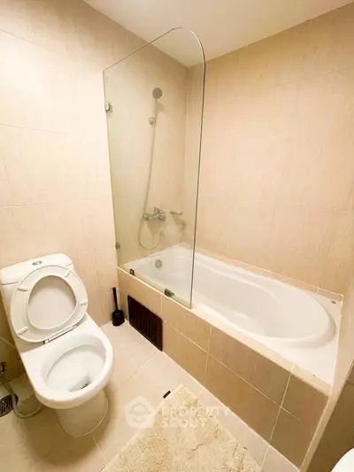 Modern bathroom with bathtub and glass shower screen in a cozy apartment.