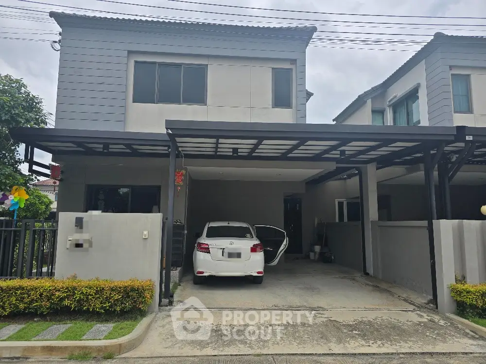 Modern two-story house with carport and well-maintained driveway in suburban neighborhood.
