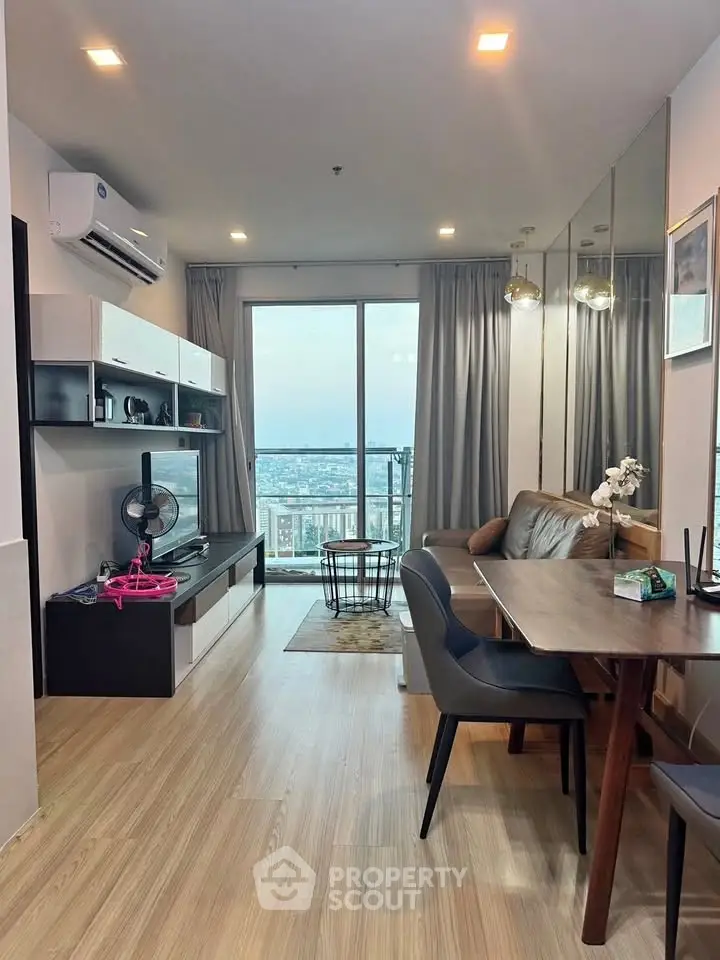 Modern living room with city view, stylish furniture, and wooden flooring in a high-rise apartment.