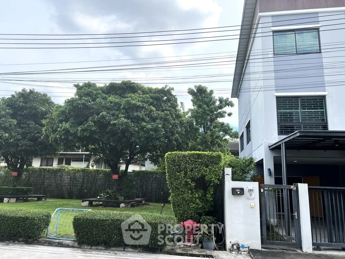 Modern residential building with lush garden and secure entrance