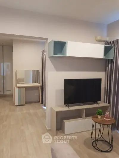 Modern living room with sleek TV stand and stylish decor in a cozy apartment.