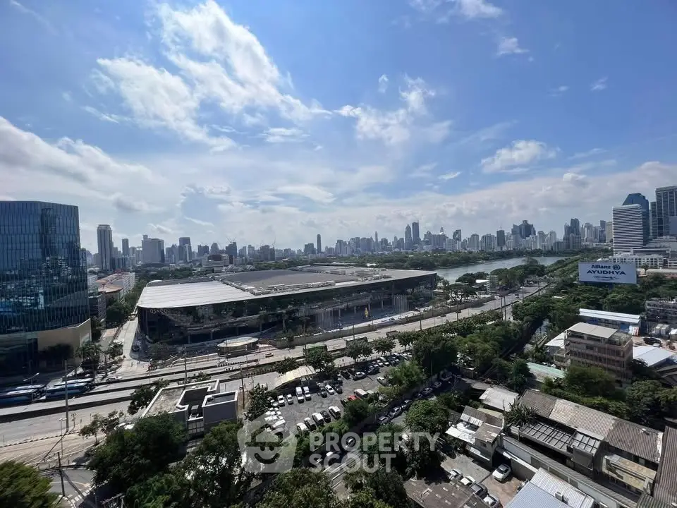 Stunning cityscape view with modern buildings and lush greenery under a clear blue sky.