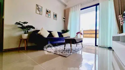 Modern living room with elegant decor and large sliding glass doors to balcony.