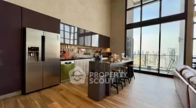 Luxurious open kitchen with modern appliances and stunning city view from high-rise apartment.
