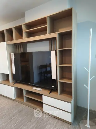 Modern living room with stylish wooden TV unit and ample storage space.