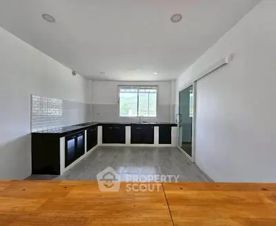Spacious kitchen with modern black cabinetry and ample natural light.