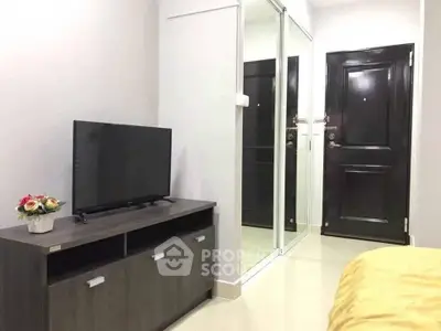 Modern bedroom with sleek TV stand and mirrored closet doors