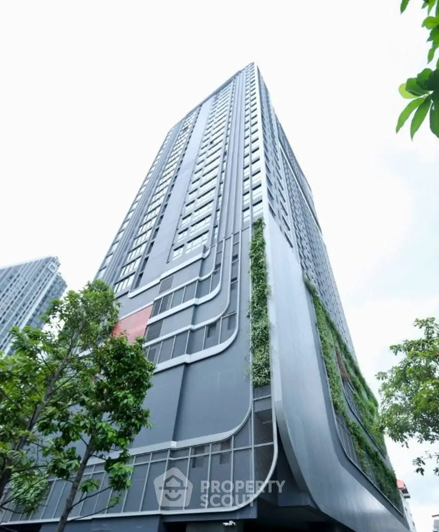Modern high-rise building with sleek design and lush greenery facade