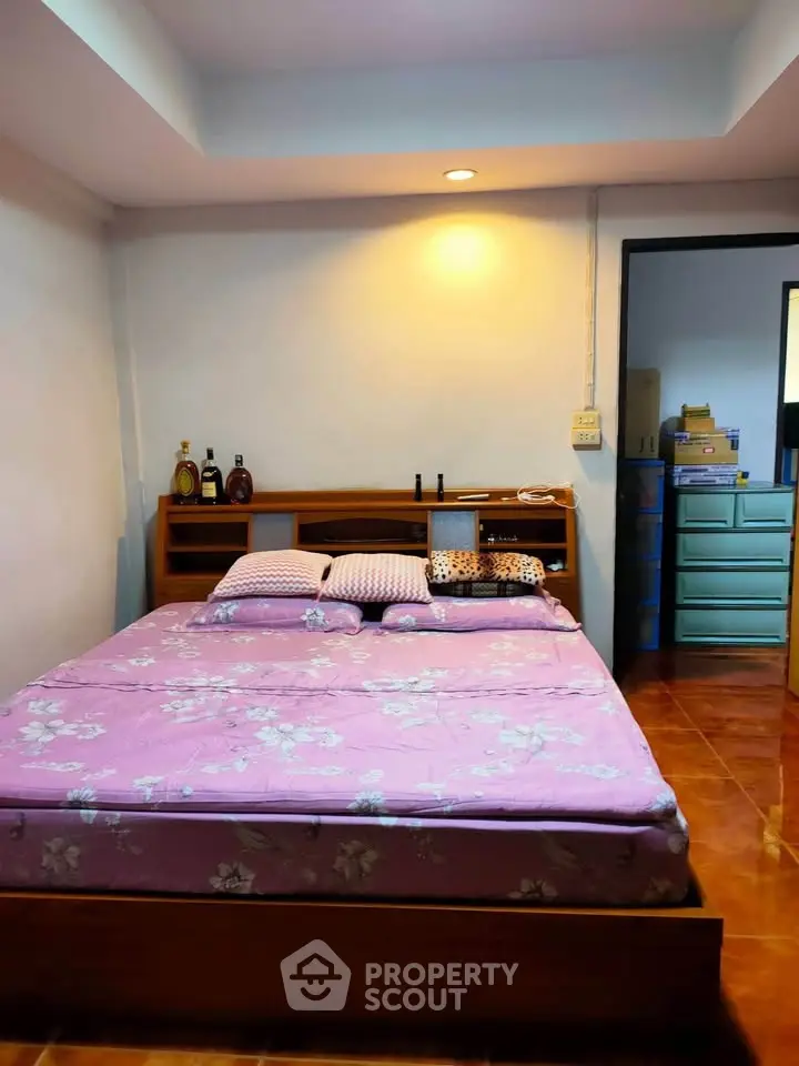 Cozy bedroom with wooden bed frame and soft lighting, perfect for relaxation.