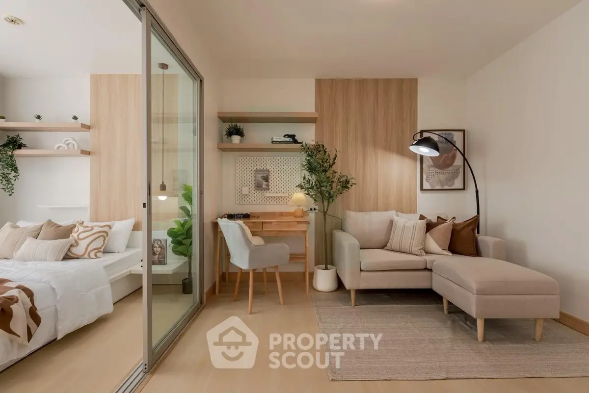 Modern living room with cozy sofa and stylish decor adjacent to a bedroom with sliding glass doors.