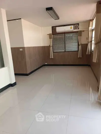 Spacious empty room with large windows and air conditioning, ideal for customization.