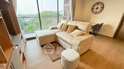 Spacious living room with modern decor and large balcony offering stunning views.