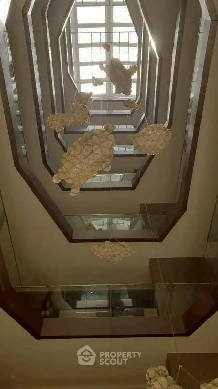 Luxurious modern building interior with unique ceiling design and artistic lighting fixtures.