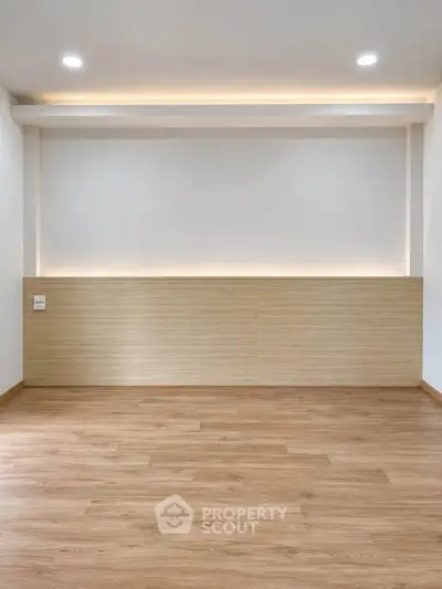Spacious modern living room with wooden flooring and recessed lighting