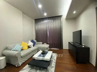 Modern living room with cozy sofa, stylish decor, and large TV, perfect for relaxation and entertainment.