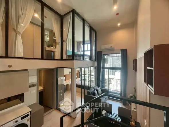 Modern loft apartment with high ceilings and large windows, featuring a stylish living area and mezzanine bedroom.