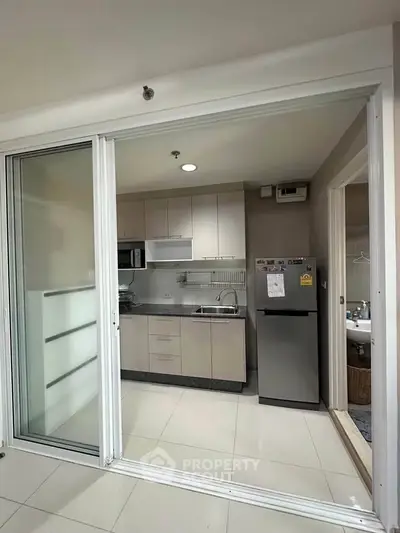 Modern kitchen with sleek cabinetry and stainless steel appliances in a compact open layout.