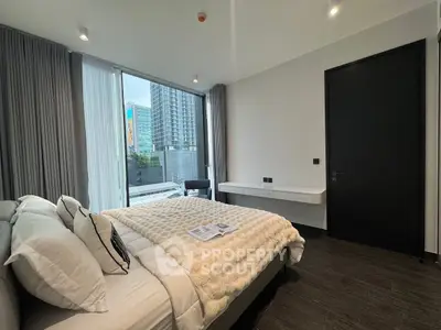 Modern bedroom with large window and city view, featuring elegant decor and cozy bedding.
