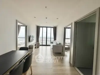 Spacious modern living room with panoramic city view and elegant furnishings.