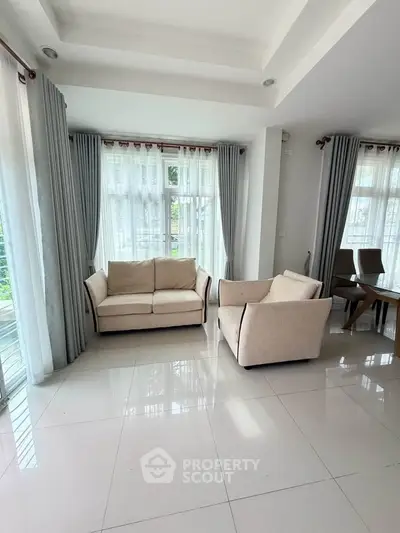 Spacious living room with elegant furniture and large windows for natural light.