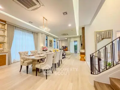Luxurious open-plan living and dining area with elegant decor and modern lighting