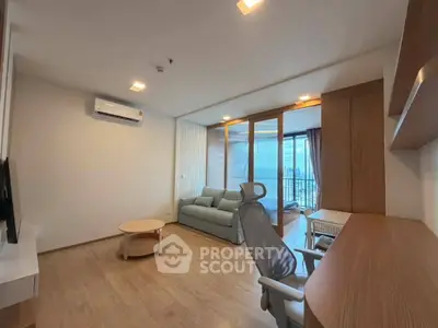 Modern living room with wooden flooring, cozy sofa, and large windows offering city views.