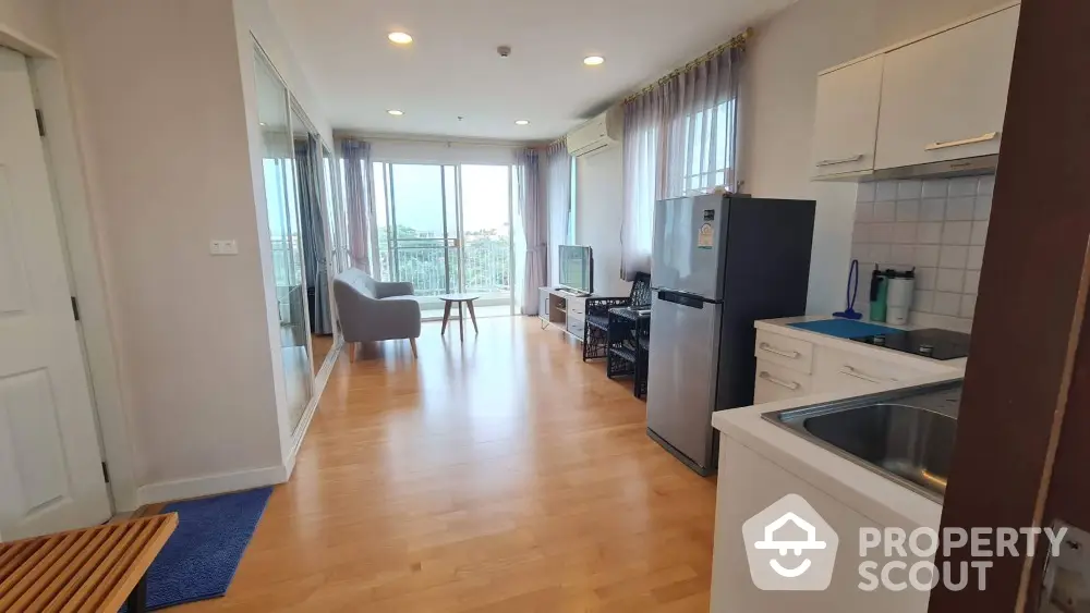 Modern open-plan living room with kitchen and balcony view