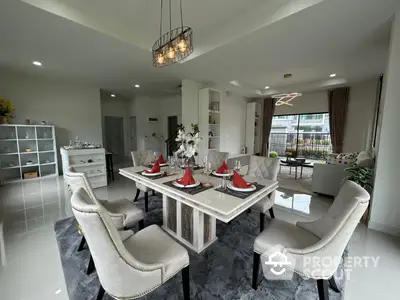 Elegant dining room with modern decor and plush seating in a luxurious home setting.