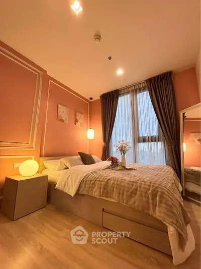 Cozy bedroom with elegant decor and large window offering natural light
