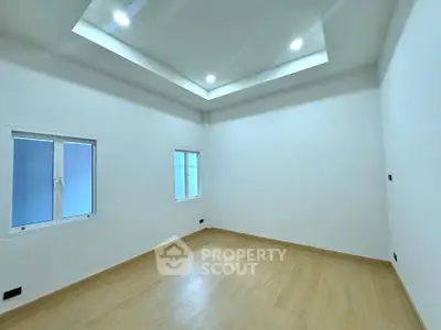 Spacious empty room with modern recessed lighting and wooden flooring, perfect for customization.