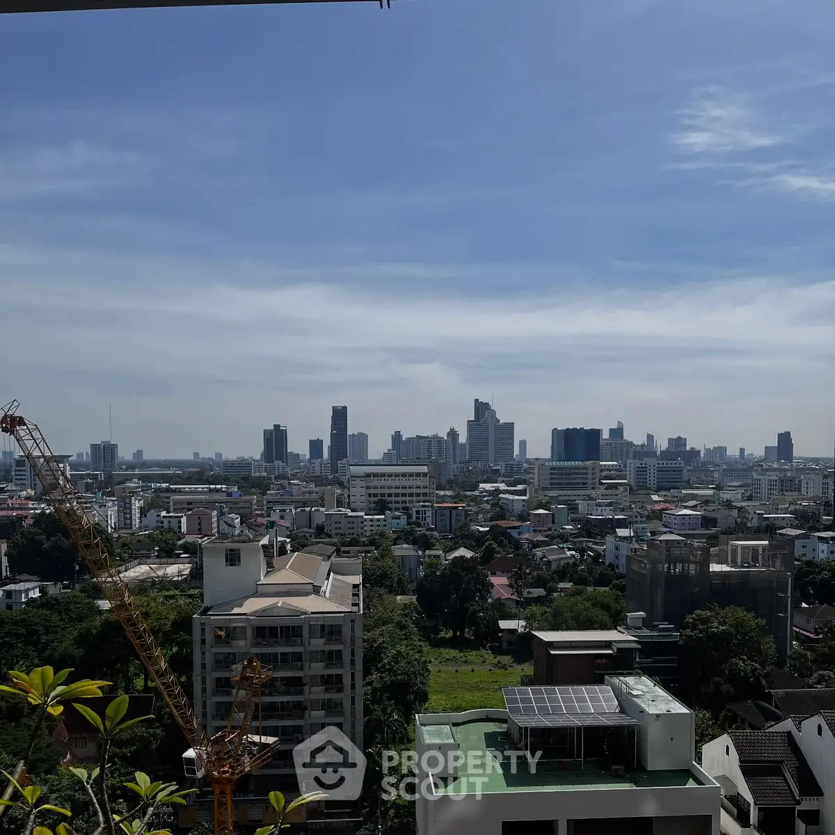 Stunning cityscape view from a high-rise balcony showcasing urban skyline and lush greenery.