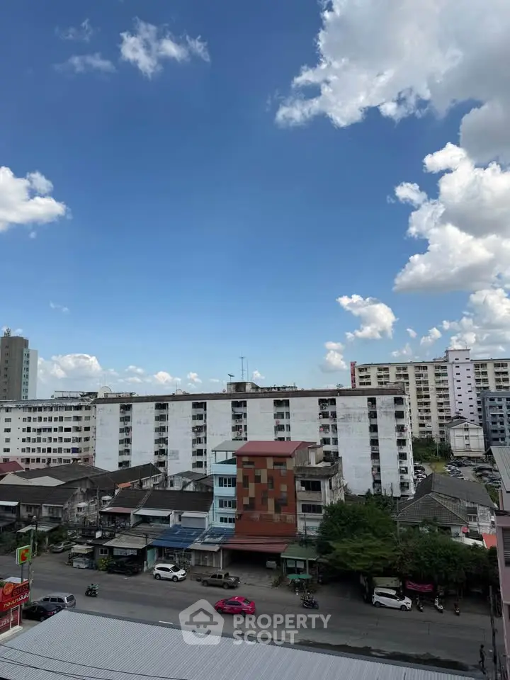 Urban cityscape view with residential buildings under a bright blue sky.