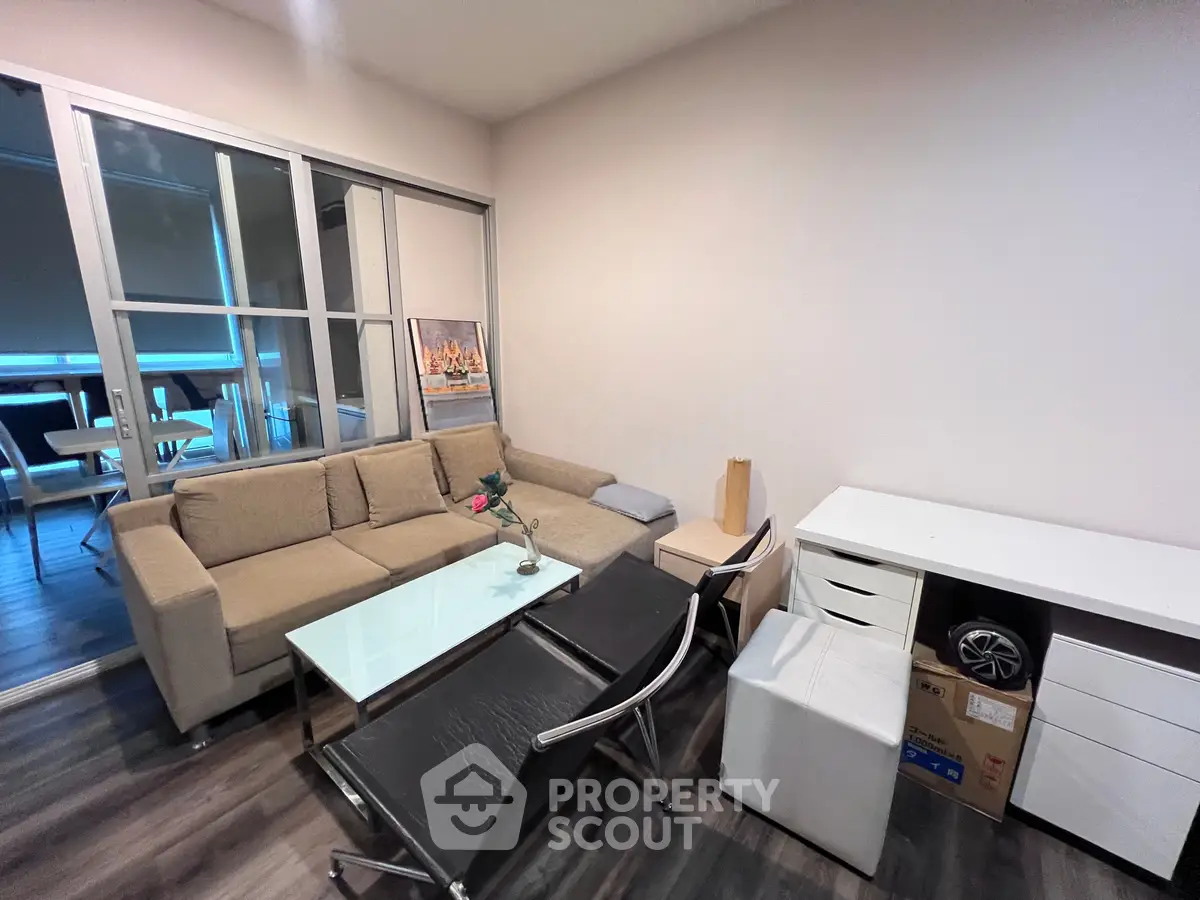 Modern living room with stylish furniture and glass coffee table, featuring a cozy ambiance and sleek design.