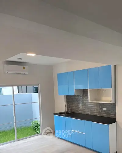 Modern kitchen with blue cabinets and sleek design in a bright, airy apartment.