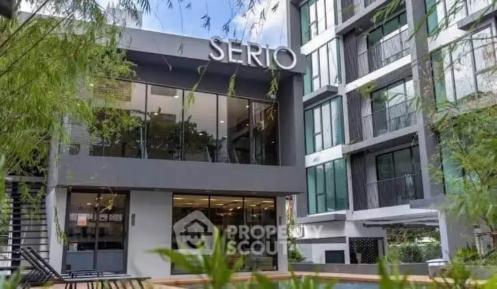 Modern apartment building exterior with lush greenery and stylish architecture.