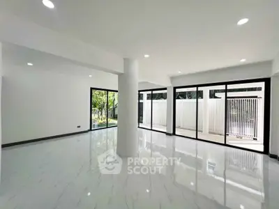 Spacious modern living room with large windows and glossy floors