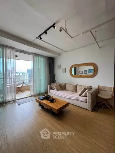 Spacious living room with modern decor and large windows offering city views.
