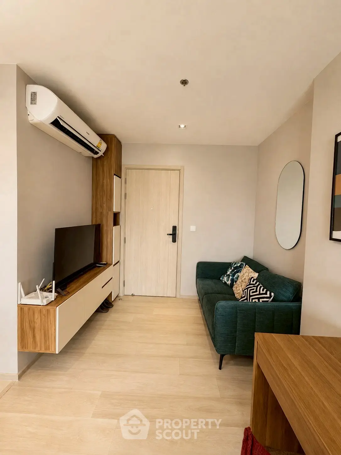 Modern living room with stylish furniture and wall-mounted TV in a cozy apartment.